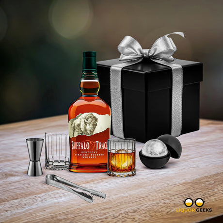 Buffalo Trace whiskey bottle with a glass, jigger, and gift box on a wooden surface.